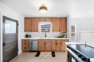 Kitchen featuring range with electric cooktop, brown cabinets, decorative backsplash, and dishwasher