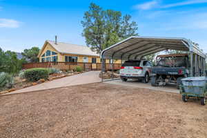 View of vehicle parking featuring driveway and a detached carport