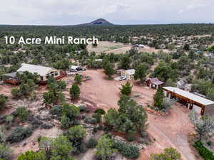Aerial view of sparsely populated area featuring a mountainous background and a forest