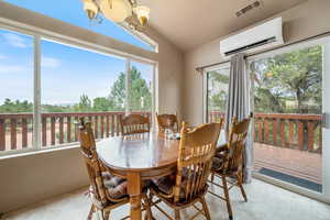Dining space featuring a chandelier, a wall mounted air conditioner, light tile patterned flooring, and vaulted ceiling