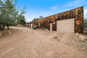 View of front of house with dirt driveway and a garage