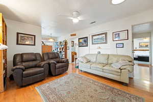 Living room featuring a ceiling fan and light wood-style flooring