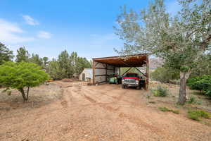View of parking featuring driveway and a detached carport