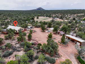 Overview of rural landscape featuring a mountainous background and a forest