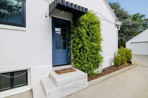 Property entrance featuring a garage and brick siding