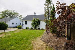 Rear view of property featuring a chimney and a shingled roof