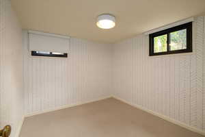 Empty room featuring wallpapered walls and carpet flooring