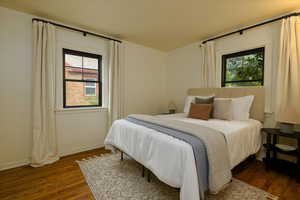 Bedroom featuring dark wood finished floors and multiple windows