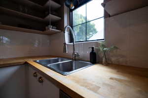 Kitchen featuring open shelves, light countertops, and backsplash