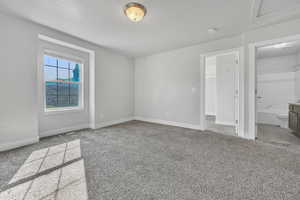 Unfurnished bedroom with light colored carpet and ensuite bath