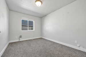 Carpeted empty room featuring baseboards