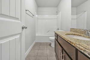Full bath with shower / bathtub combination, vanity, and light tile patterned floors
