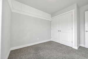 Unfurnished bedroom featuring carpet and a closet