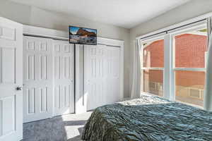 Carpeted bedroom featuring two closets and multiple windows