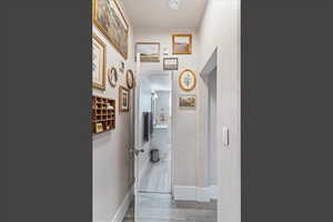 Hall featuring light wood-style floors and a textured wall