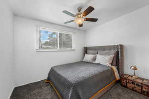 Carpeted bedroom featuring ceiling fan and baseboards