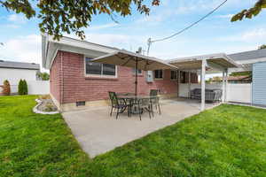 Rear view of house with a patio and brick siding
