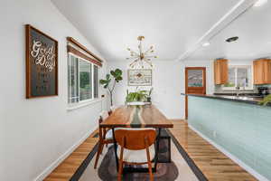 Dining area featuring light wood-style floors, a chandelier, recessed lighting, and beamed ceiling