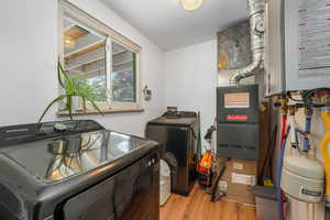 Utility room featuring tankless water heater, washer and dryer, and heating unit