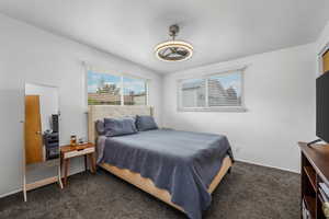 Carpeted bedroom featuring baseboards and a ceiling fan