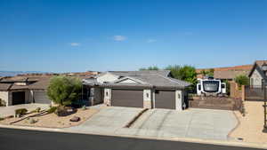 Ranch-style house featuring driveway, an attached garage, a tiled roof, stone siding, and a gate