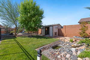 Fenced backyard featuring a patio area and an outbuilding