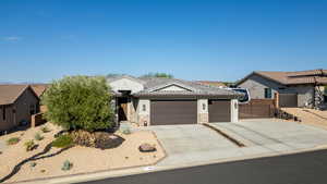 Ranch-style house with a garage, driveway, stone siding, and a tiled roof