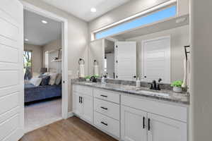 Ensuite bathroom with light wood-type flooring, double vanity, and recessed lighting