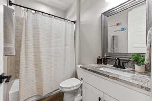 Bathroom featuring shower / bath combo with shower curtain and vanity