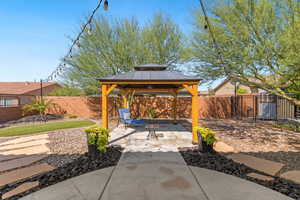 Fenced backyard featuring a patio and a gazebo