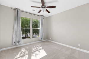 Spare room featuring carpet floors and a ceiling fan