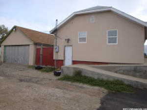 Back of property featuring a garage, stucco siding, and driveway