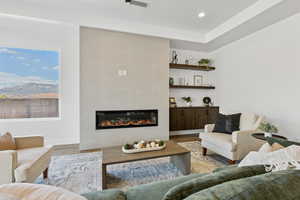 Living area with a fireplace, wood finished floors, and recessed lighting