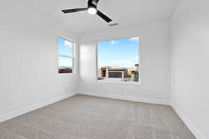 Empty room with light carpet and a ceiling fan