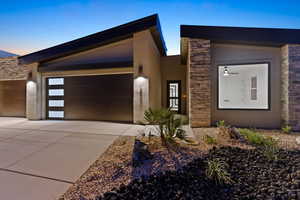 Contemporary home with stone siding, concrete driveway, an attached garage, and stucco siding