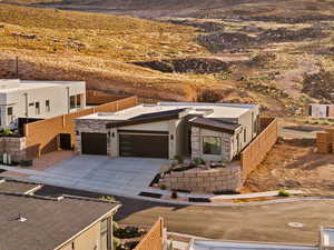 Modern home with concrete driveway, a garage, stone siding, and a mountain view
