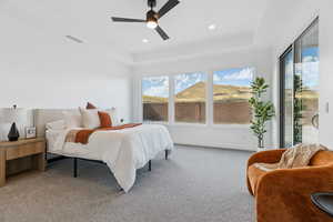Carpeted bedroom with access to outside, a tray ceiling, ceiling fan, and recessed lighting