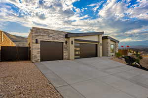 Modern home featuring a mountain view, stone siding, and a garage