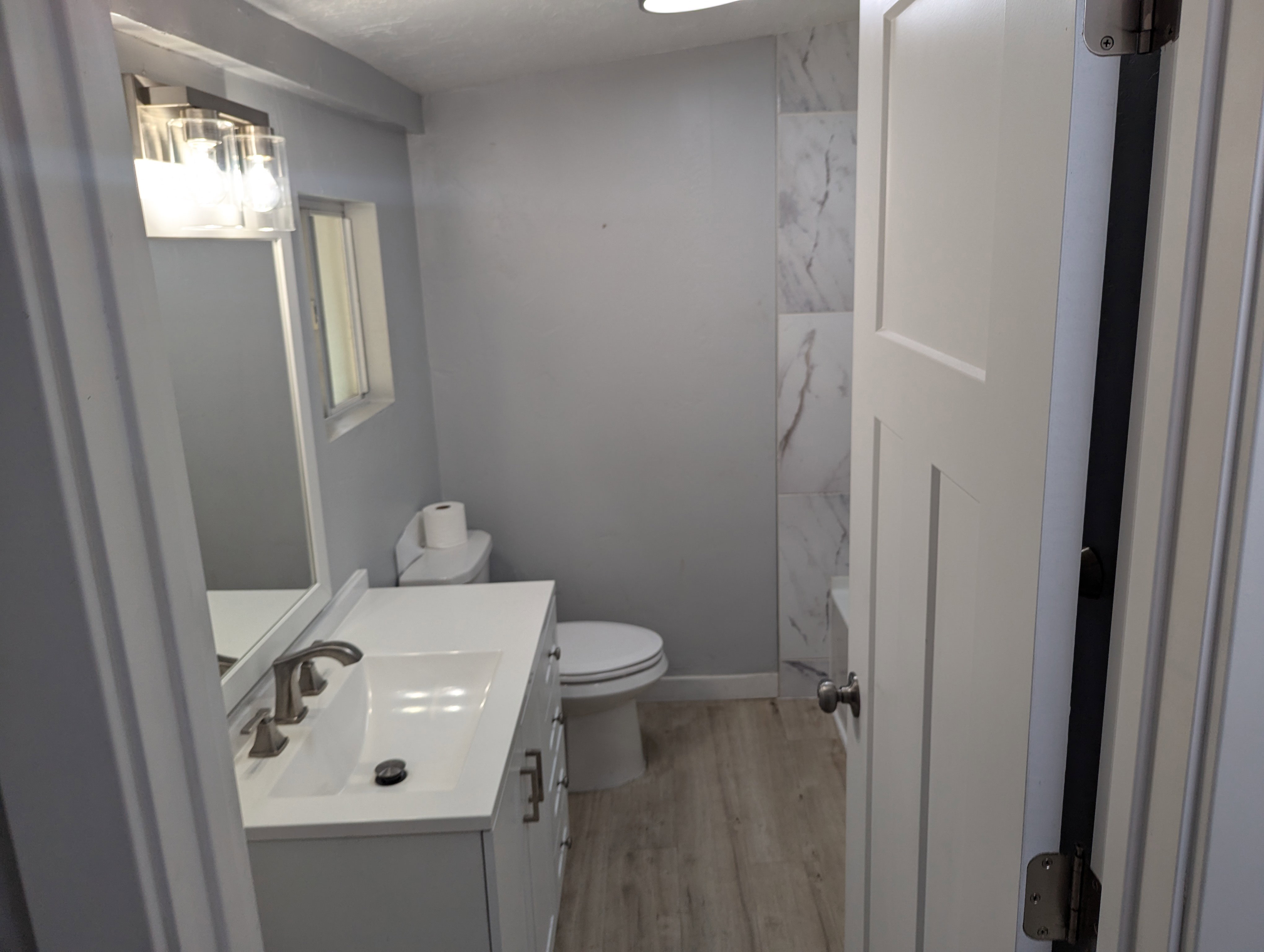 Full bath with vanity and light wood finished floors