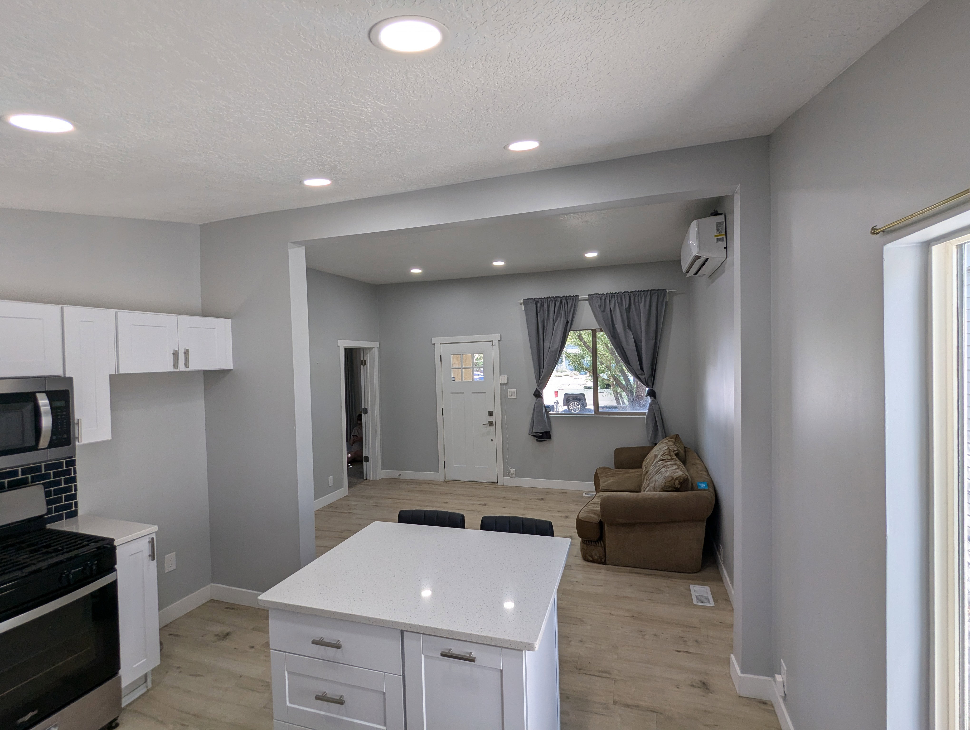 Kitchen with appliances with stainless steel finishes, recessed lighting, open floor plan, white cabinets, and light wood-style flooring
