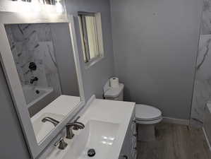 Full bath with vanity, light wood-style floors, and shower / bath combination