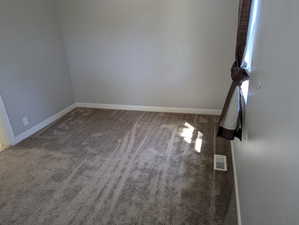 Unfurnished room with baseboards and light carpet