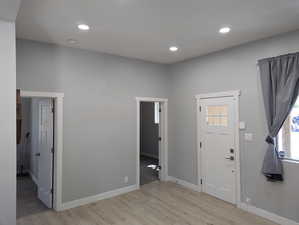 Foyer with light wood-style floors and recessed lighting