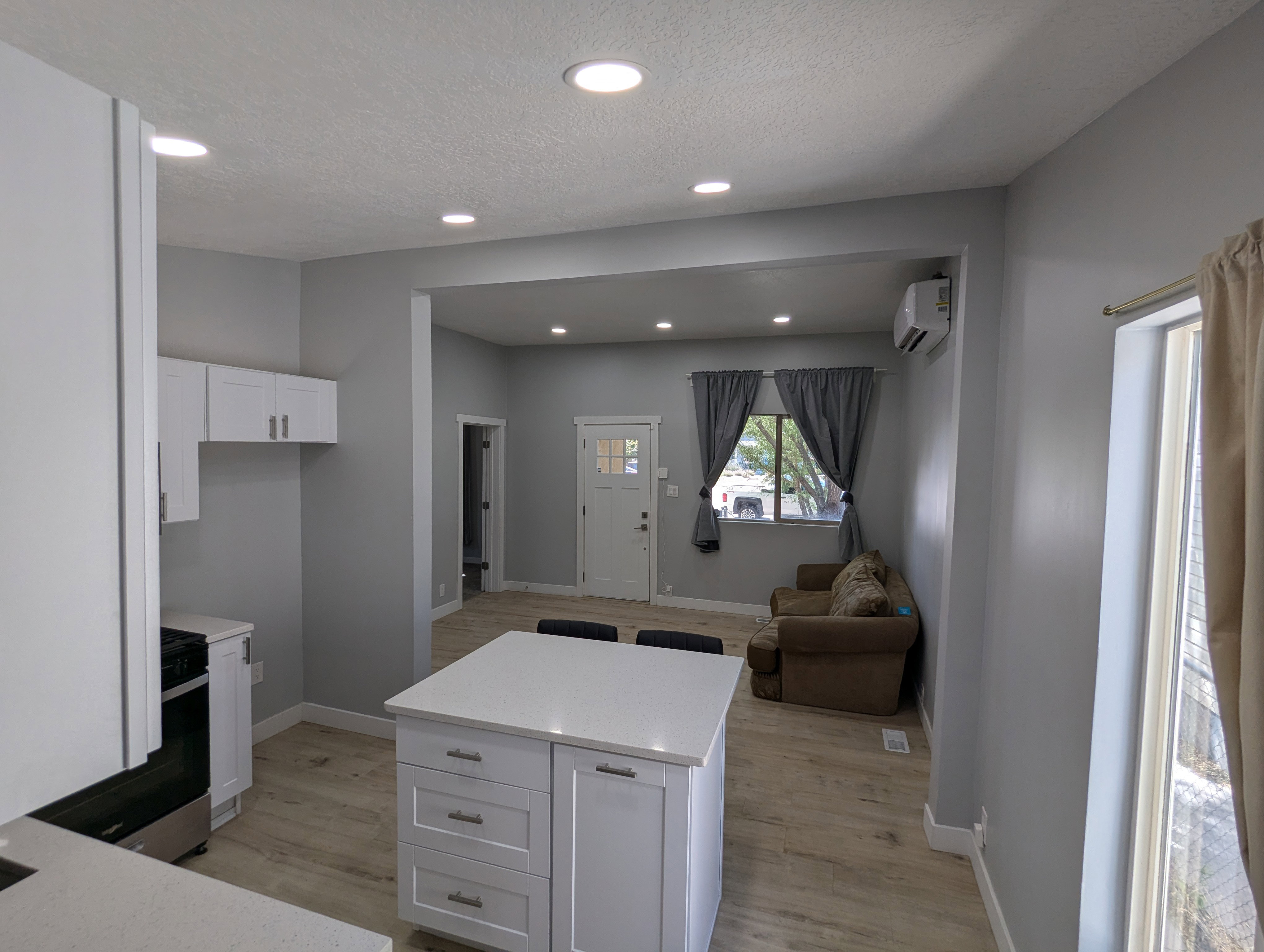 Kitchen featuring white cabinetry, recessed lighting, open floor plan, light wood-type flooring, and stainless steel range oven