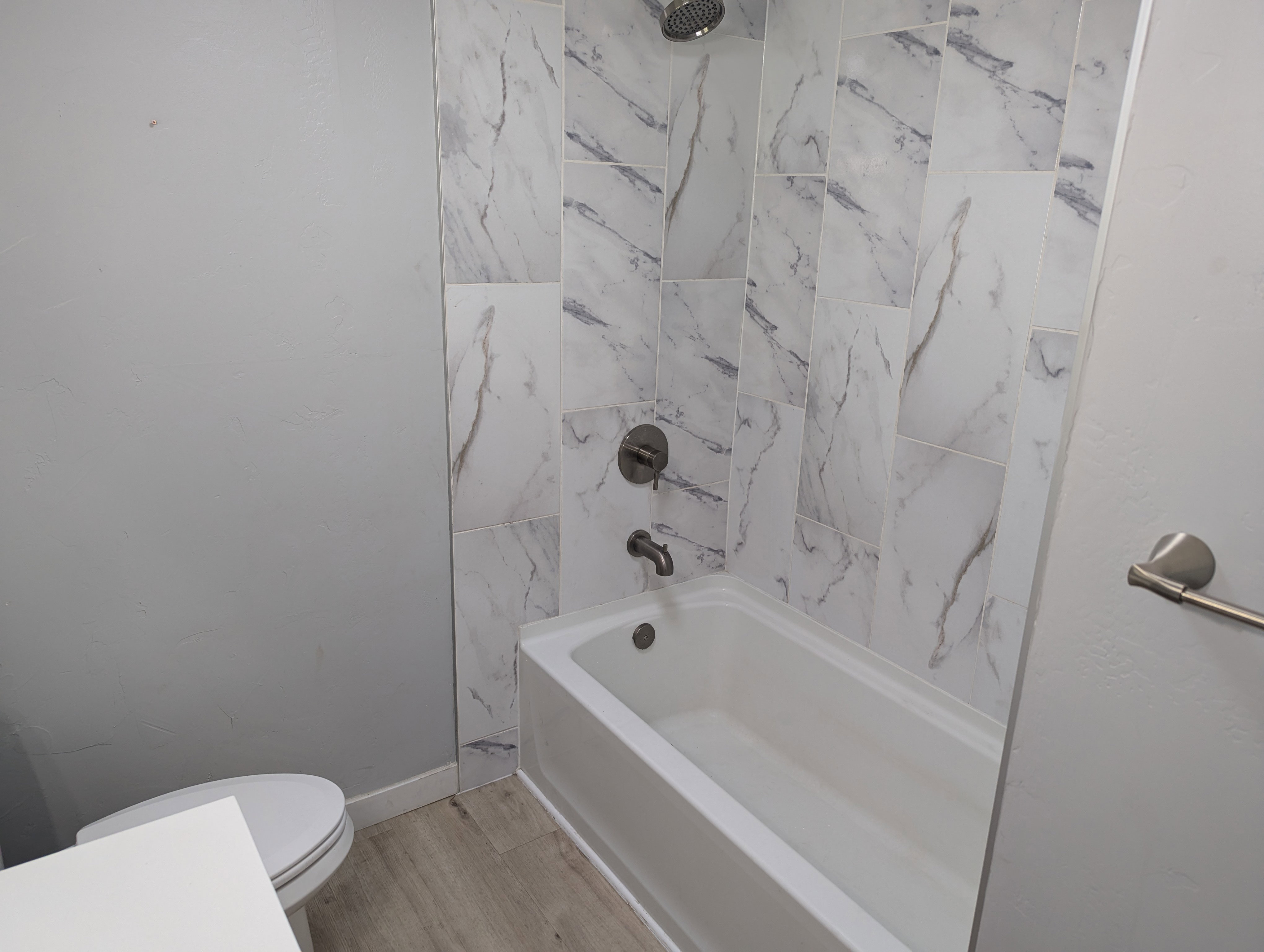Full bathroom with  shower combination and light wood-style floors