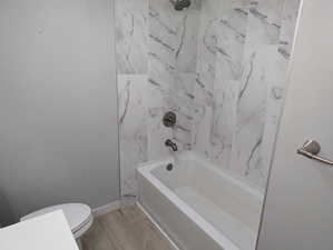 Full bathroom with  shower combination and light wood-style floors