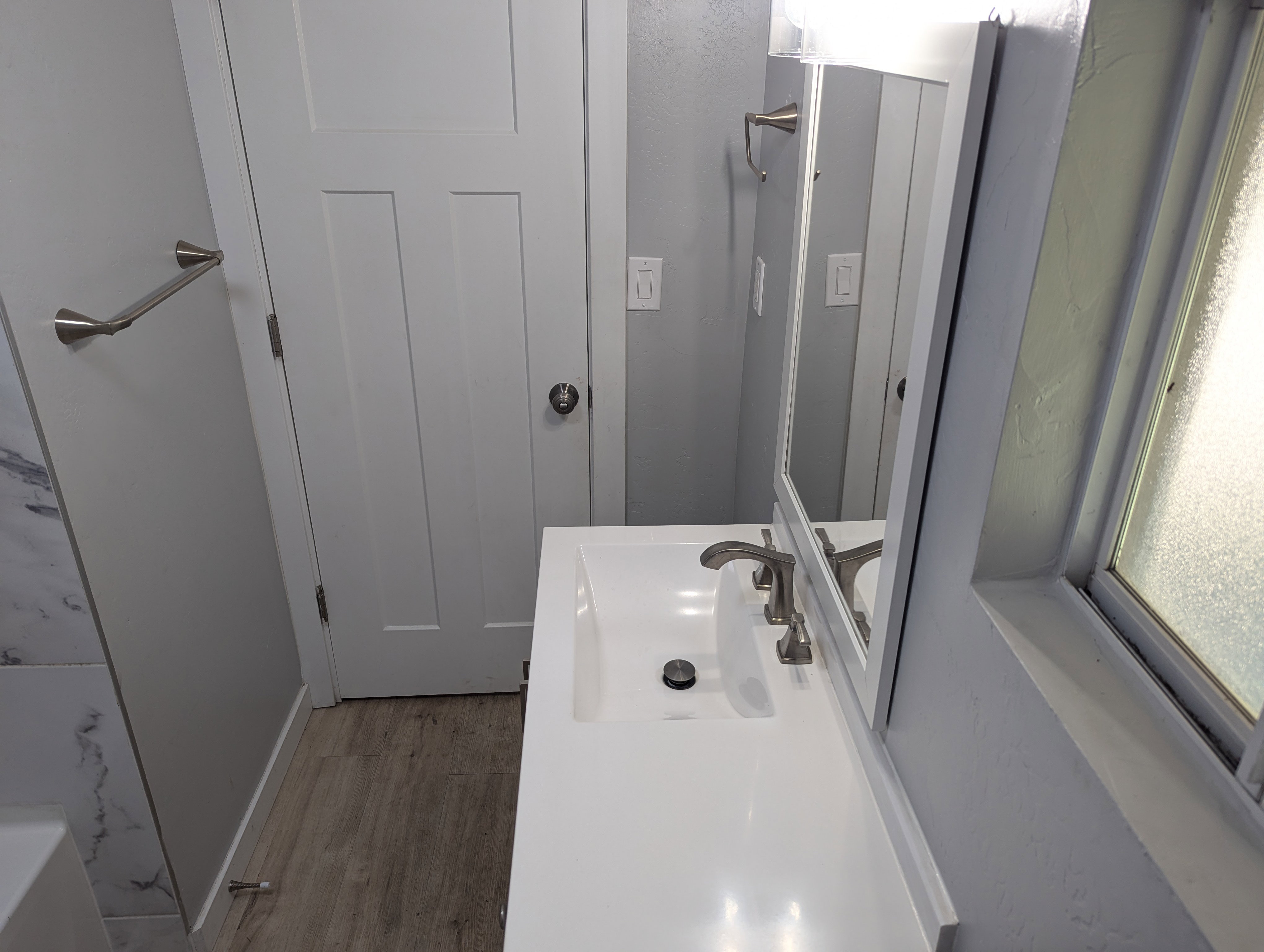 Full bathroom featuring light wood-style floors and vanity
