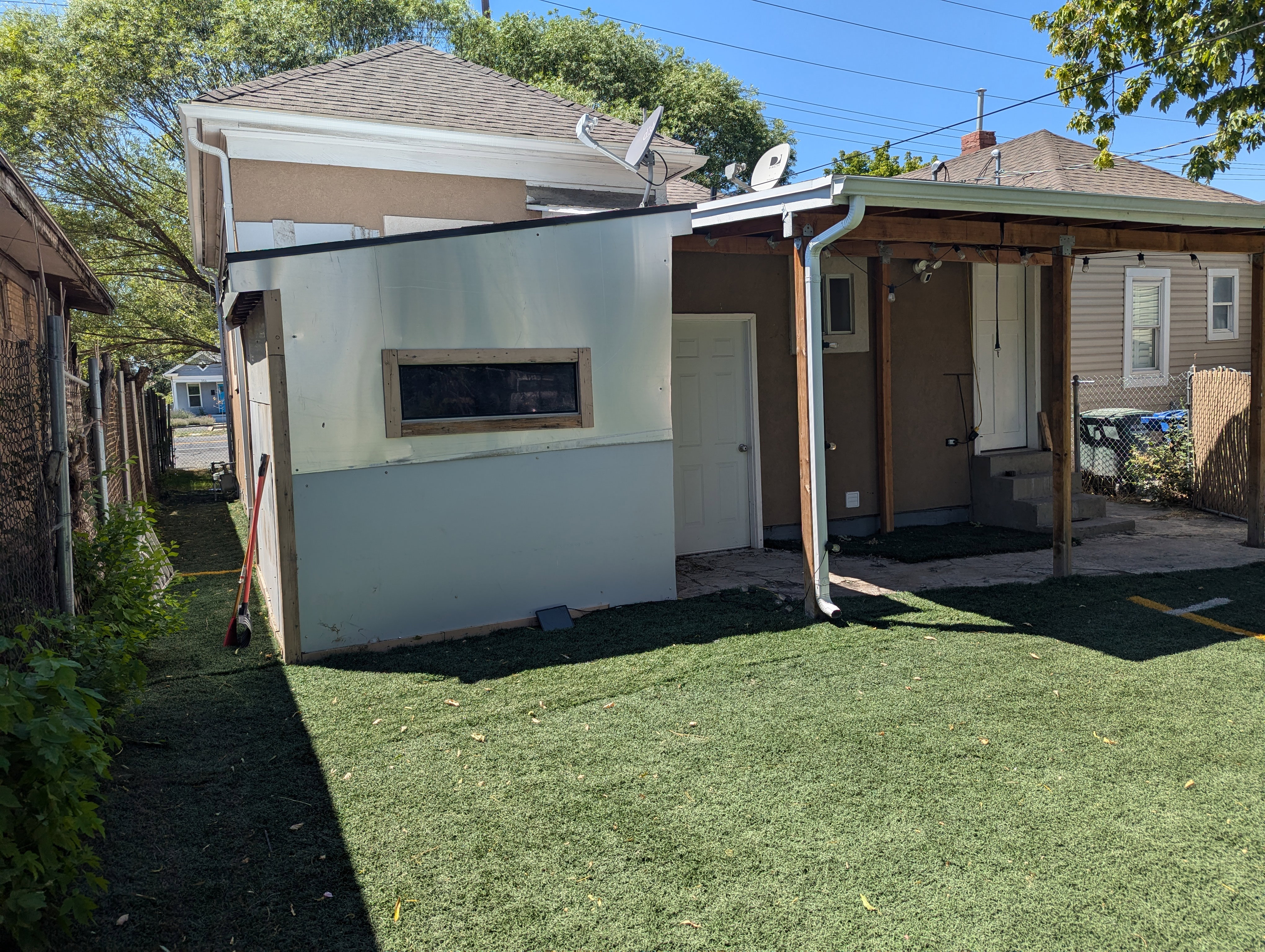 Back of property featuring a chimney and stucco siding