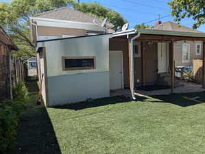 Back of property featuring a chimney and stucco siding
