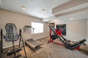 Exercise area featuring baseboards and carpet